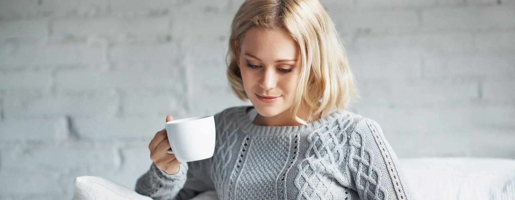 woman on couch with a cup of coffee