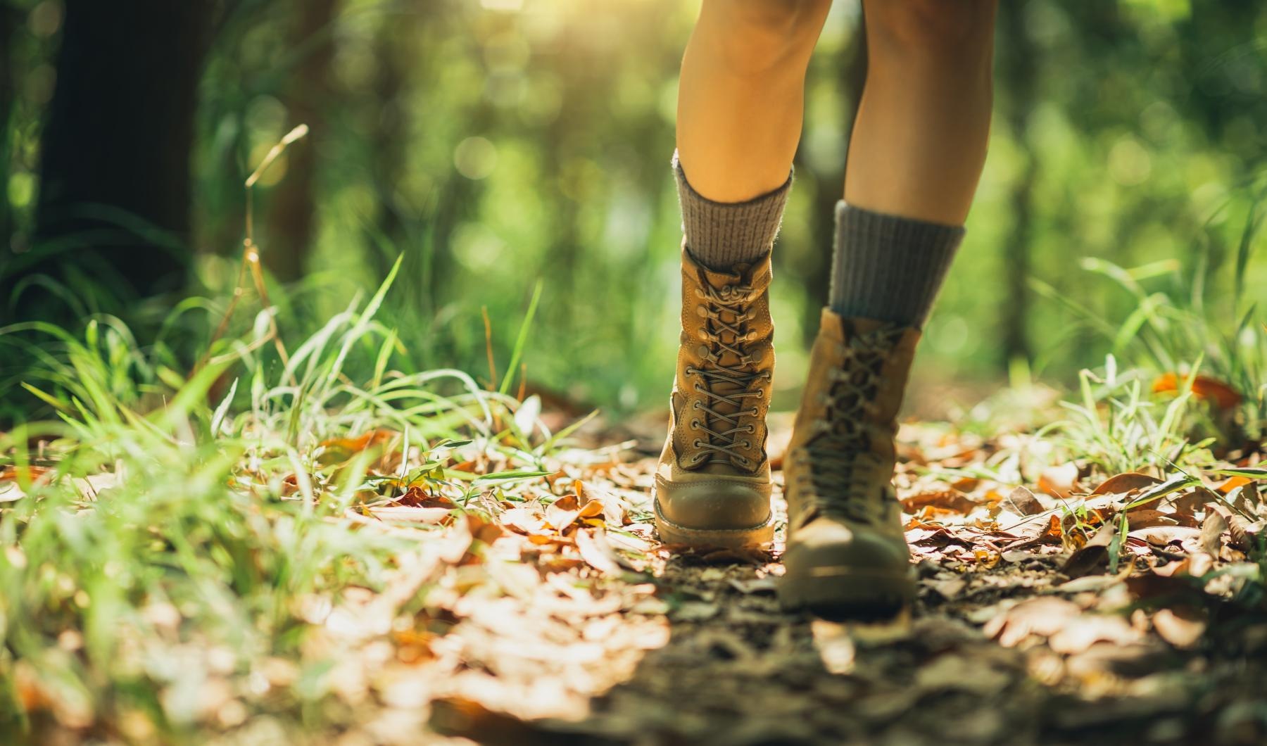 a person's legs in boots and boots walking on a path