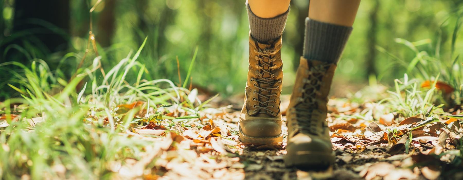 a person's legs in boots and boots walking on a path
