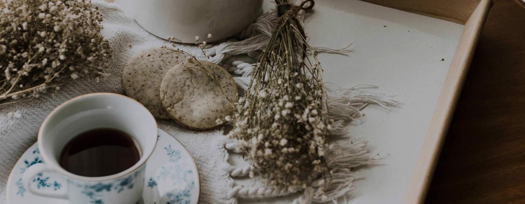 tea and cookies on a serving tray with baby's breath